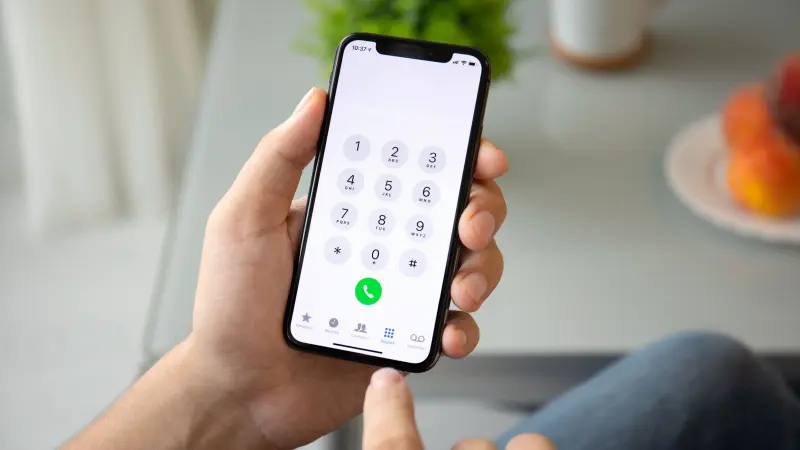A person holding a phone about to dial a number